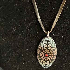 Pendant with leather rope.